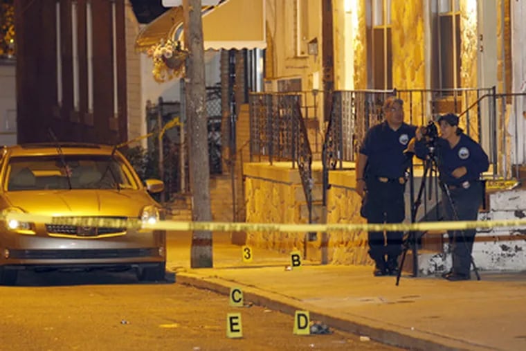 Police investigators photograph the scene of a multiple shooting on the 1200 block of Bucknell Street in South Philadelphia on Tuesday. (Yong Kim / Staff Photographer)