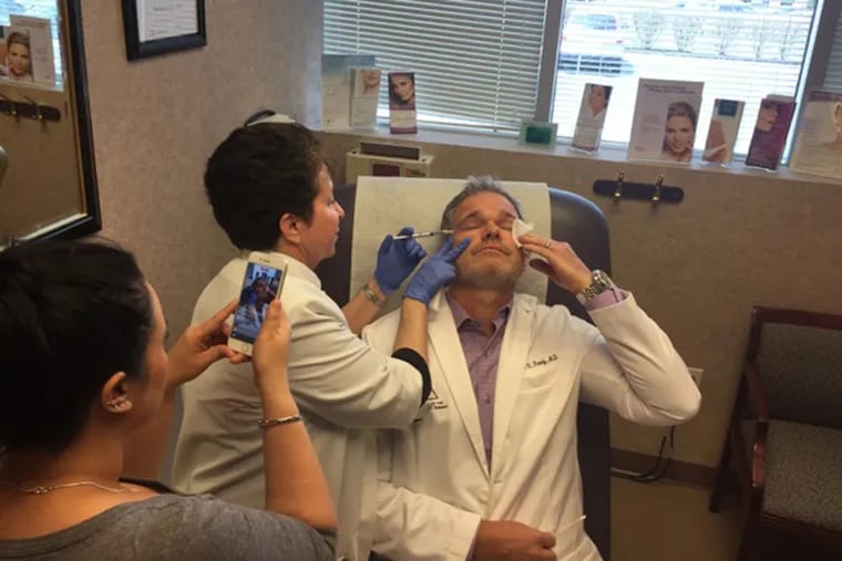 Dr. Brian K. Reedy, a board-certified plastic surgeon in Wyomissing. has tried a novel way to publicize his business: Having his office staff administer Botox injections and non-invasive fat removal — on Reedy — on Facebook Live. Here, registered nurse Maria Fotis injects the doctor with Botox, as receptionist Michelle O’Grady records.