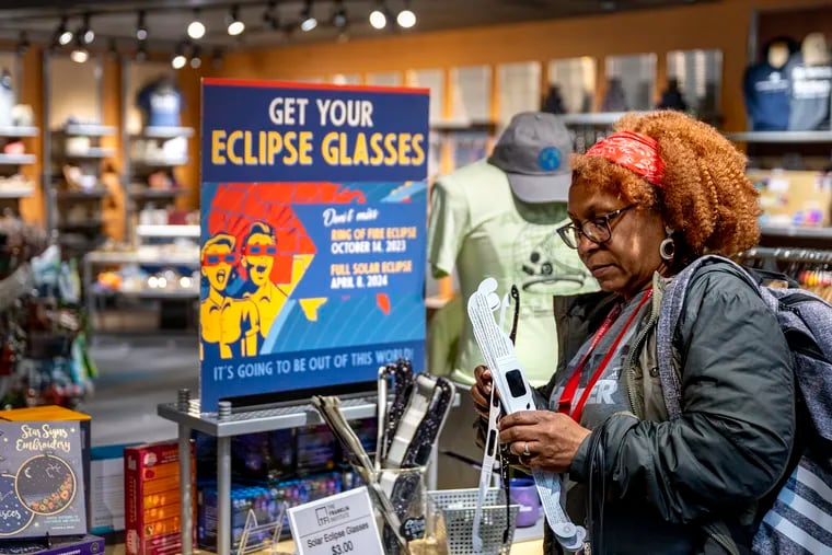 Elaine Allen of Cherry Hill buys eclipse glasses in the gift shop at the Franklin Institute Sunday. The museum will host a free communitywide eclipse viewing party on Monday, with special solar filter tents (designed by chief astronomer Derrick Pitts) set up in front of the museum's steps, along the 20th Street sidewalk, where Pitts will host the event, from 1:30 to 5 p.m. to safely observe the solar eclipse.