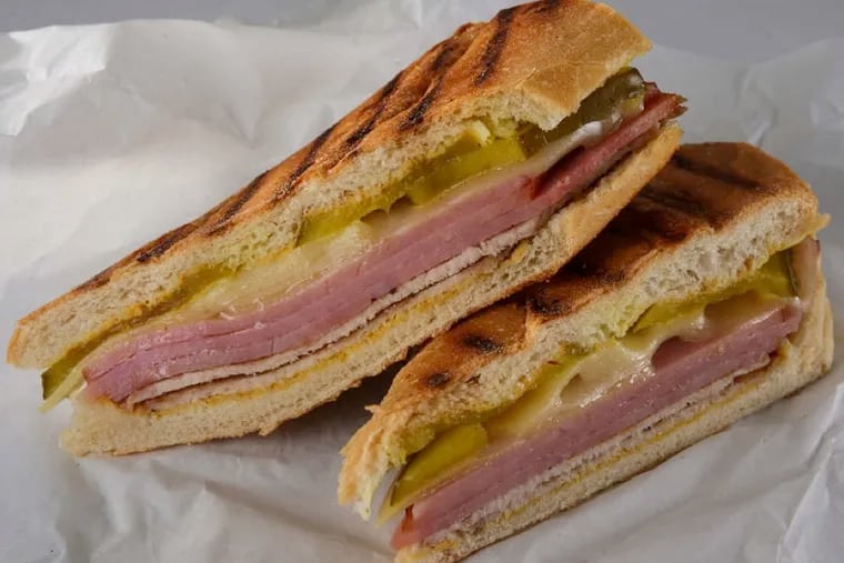 A traditional Cuban sandwich recipe calls for sliced ham, roast pork with a citrusy marinade (called mojo) and Swiss cheese layered in a loaf of Cuban bread. The sandwich is then garnished with pickles and mustard. (Zbigniew Bzdak/Chicago Tribune/MCT)