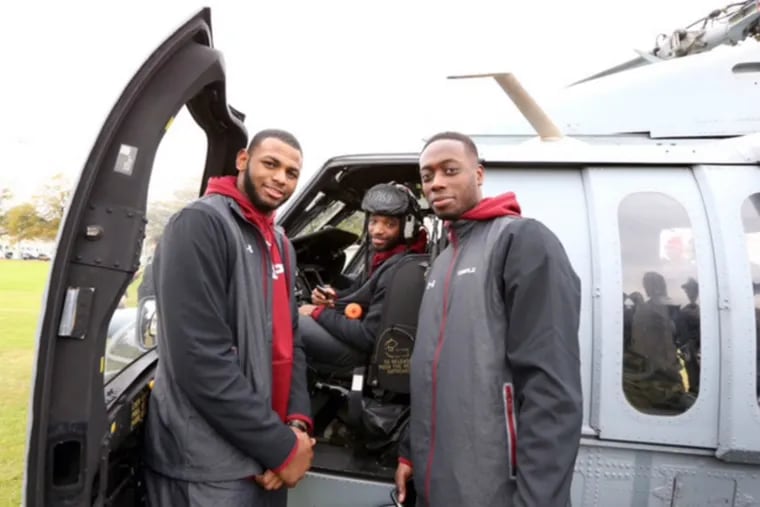 From left, Owls players Jaylen Bond, Josh Brown and Quenton DeCosey pose with helicopter.