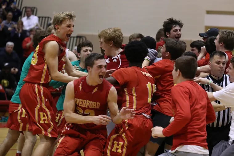 Haverford  players, including Hunter Kraiza (left) and John Scheivert (center) celebrate their victory over Penncrest in the Central League boys’ basketball championship game at Harriton High School.