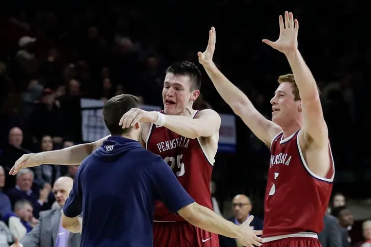 Penn forward AJ Brodeur (center) hugs teammate forward Max Rothschild (left) as guard Jake Silpe raises his arms after Penn beat St. Joe's 78-70 for the Big-5 title at The Palestra on Saturday, January 26, 2019.