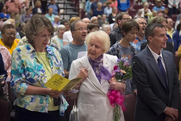 Anna Wright (center), 89, of Newtown Square, who was in attendance 60 years earlier when Martin Luther King Jr. addressed a convention of Quakers in Cape May, stands to join in singing "America the Beautiful" at the conclusion of the city's commemoration of the anniversary June 27, 2018. With her are her daughter Lisa Lister and nephew James TerBush.