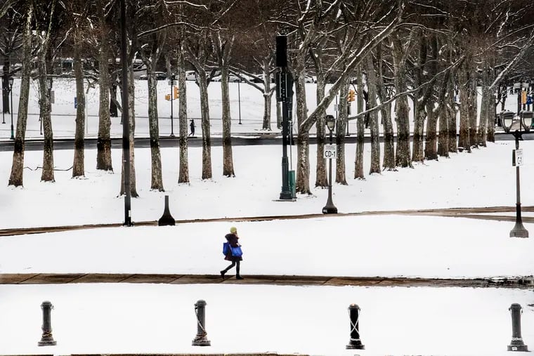 Pedestrians walk along the snow covered grounds along Eakins Oval in Philadelphia on Jan. 13. Forecasters are saying more cold and storminess likely.