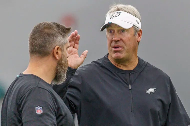 Eagles head coach Doug Pederson, right, speaks with an assistant coach on the last day of minicamp, inside the indoor practice facility at the Novacare Center on Thursday.