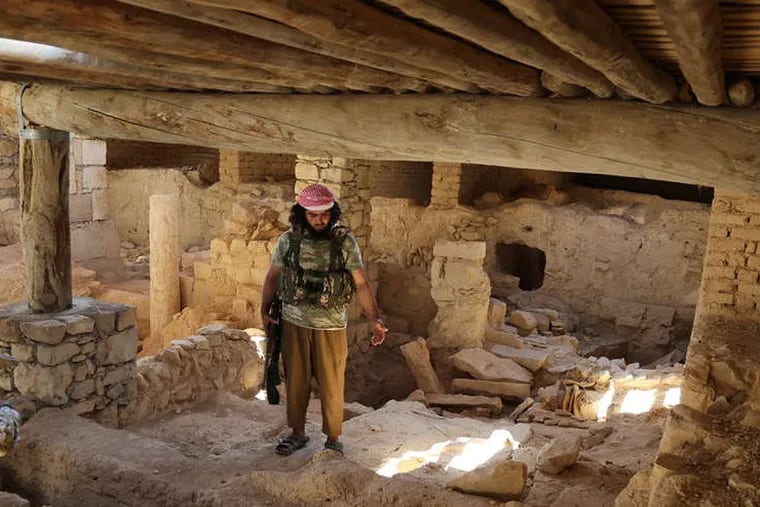 Islamic State militants stand inside the 1,500-year-old Saint Elian Monastery in Homs province, Syria. The area was seized earlier this month.