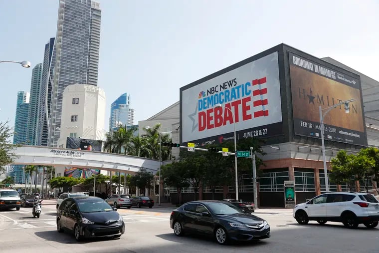 Cars pass by a billboard advertising the Democratic Presidential Debates across from the Knight Concert Hall at the Adrienne Arsht Center for the Performing Arts of Miami-Dade County, Tuesday, June 25, 2019, in Miami. The debates are scheduled to take place June 26 and 27, with 10 candidates competing each night.
