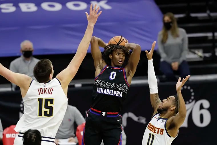 Sixers guard Tyrese Maxey passes the basketball betweenDenver Nuggets center Nikola Jokic and guard Monte Morris during the second quarter Saturday. Maxey finished with a career-high 39 points.