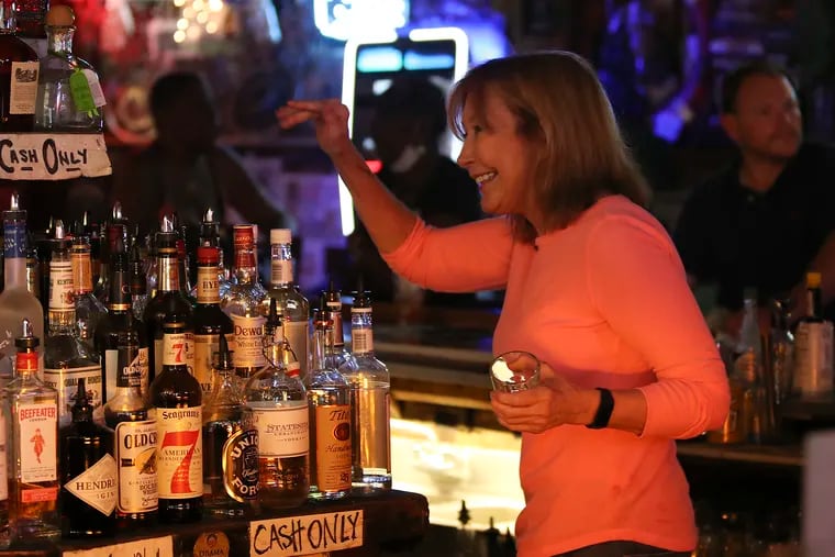 Sharon Suleta waves before pouring a drink while bartending at Dirty Franks. Suleta announced a bucket list that serves as a love letter to Philadelphia and bartending at Dirty Franks is on her list.