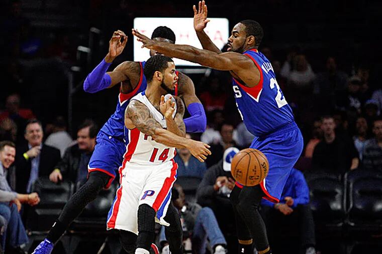 Pistons guard D.J. Augustin passes the ball around 76ers guard Elliot Williams. (Raj Mehta/USA Today Sports)