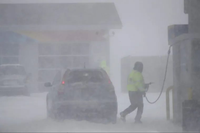 A gas station employee finishes pumping gas on a vehicle at the Monmouth Service Station along the Garden State Parkway during a snowstorm, Thursday, Jan. 4, 2018, in Wall Township, N.J.