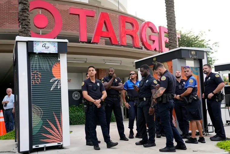Police officers stand outside of a Target store as a group of people across the street protest against Pride displays in the store on June 1, 2023, in Miami. Target confirmed that it won't be carrying its LGBTQ+ merchandise for Pride month in June, 2024, in some stores after the discount retailer received backlash last year for its assortment.