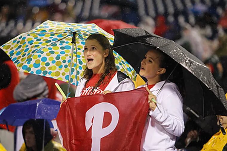 Fans had to wait out a long rain delay before watching the Phillies beat the Braves. (Ron Cortes/Staff Photographer)