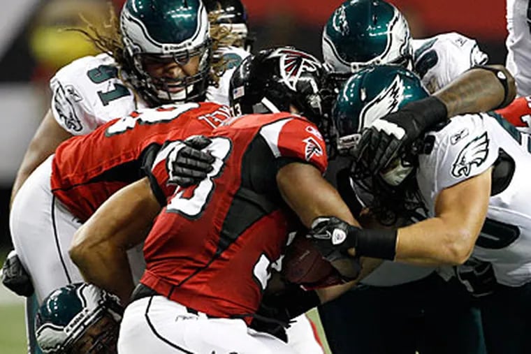 The Eagles defense goes after Falcons running back Michael Turner during the first quarter. (Yong Kim/Staff Photographer)