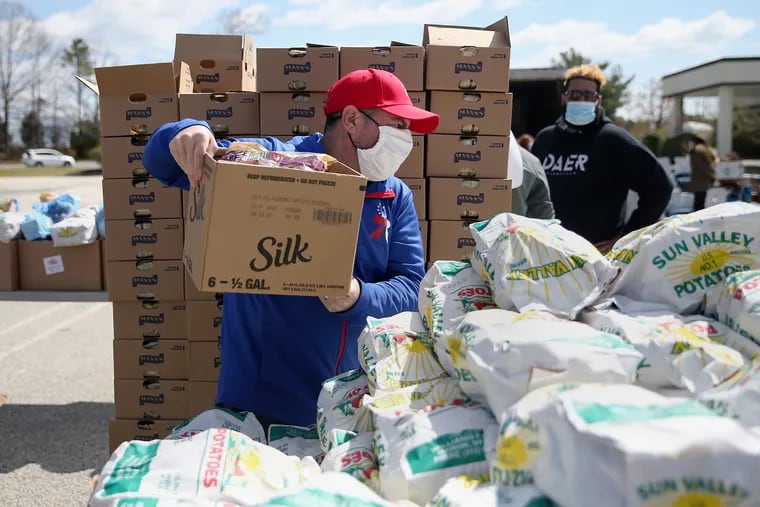 Joe Giacomo helps package items during a food distribution for casino workers at Harbor Square in Egg Harbor Township, N.J., on Wednesday, April 22, 2020. Hundreds of cars lined up to receive food at the event, which was organized by Unite Here Local 54 and the Community Food Bank of New Jersey.