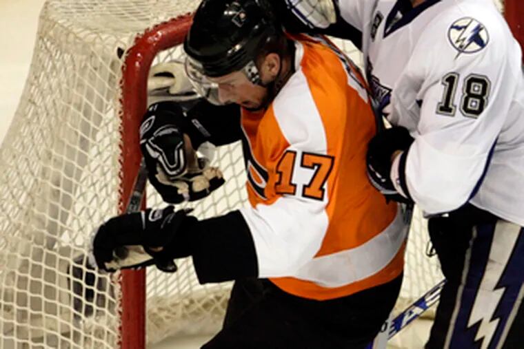 Flyers&#0039; Jeff Carter, shown with Tampa Bay&#0039;s Adam Hall, agreed that the lack of practice recently may have led to some sloppy play.