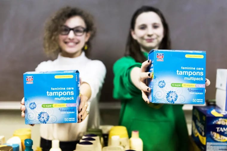 Iris Peron-Ames (left), 14, and Sasha Mannino, 13, in the conference room of Greenfield Elementary School in Center City. The two eighth-grade girls organized a drive to collect tampons for first-generation, low-income students at the University of Pennsylvania.