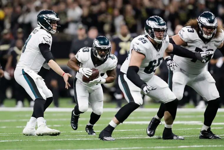 Eagles quarterback Nick Foles hands the football to running back Darren Sproles with offensive linemen Lane Johnson and Isaac Seumalo against the New Orleans Saints in a NFC Divisional playoff game on Sunday, January 13, 2019 in New Orleans. Sproles has signed for another season.