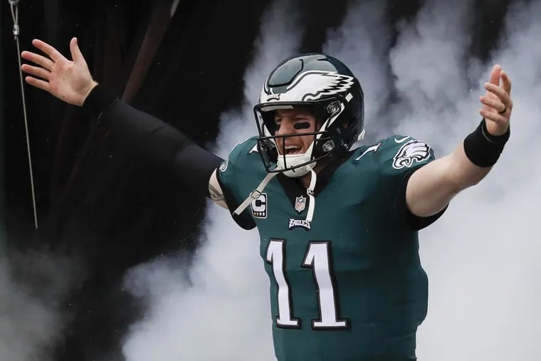 Eagles quarterback Carson Wentz walks through the smoke during player introductions before the Eagles played the Indianapolis Colts on Sunday, September 23, 2018 in Philadelphia.