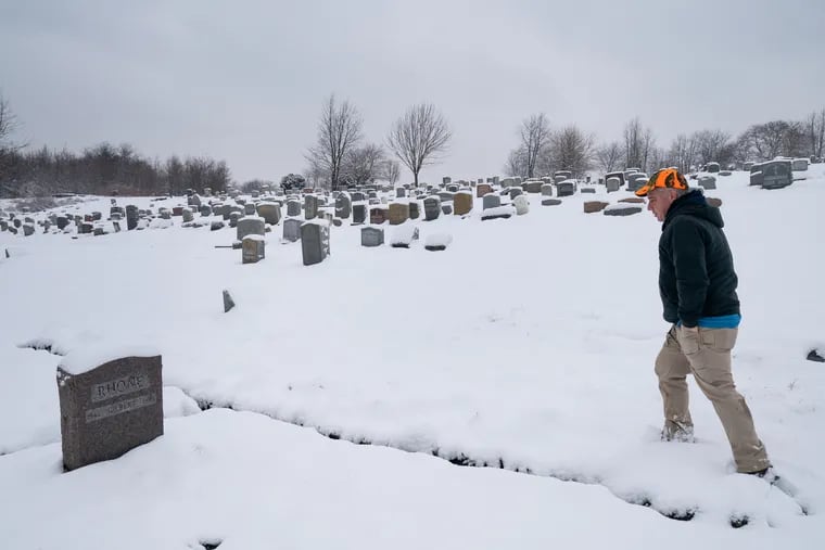 Ken Smith at the grave of Gilbert Rhone, husband to recently deceased cemetery advocate Paulette Rhone, at the Mount Moriah Cemetery, in Philadelphia, Friday, March 1, 2019.