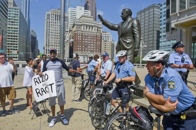 Black Lives Matter  member Asa Khalif berates Philadelphia police after the hood he placed atop the head of the Frank Rizzo statue outside the Municipal Services Building was removed Aug. 12, 2016.