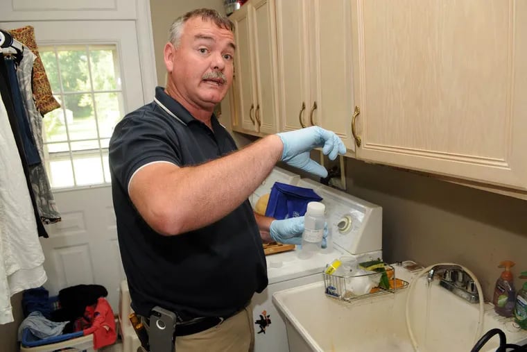 John Scully, of Private Utility Enterprises Inc., takes a water sample Tuesday, Aug. 16, 2016, at the Ambler home of Jerry and Ann Henner.