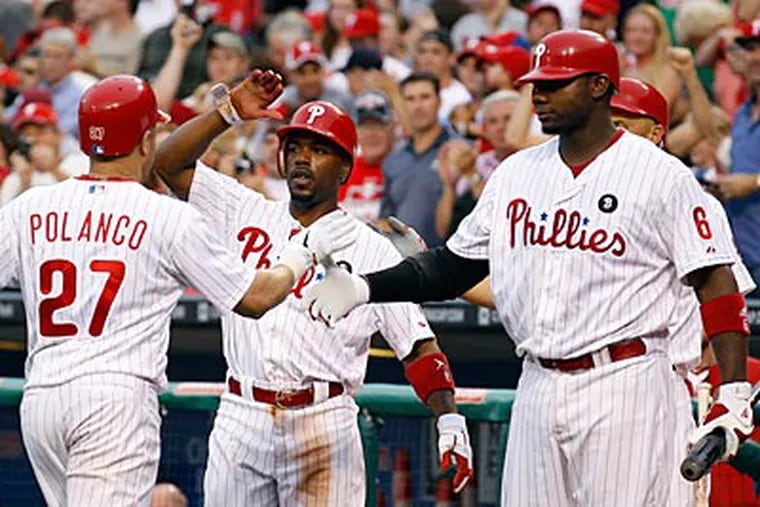 Jimmy Rollins and Ryan Howard celebrate Placido Polanco's two-run home run in the first inning. (Yong Kim/Staff Photographer)