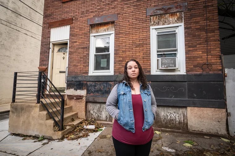 Linsey Franklin stands in front of her family's former home in Fishtown.  Her advocacy, after she had to fight an Act 135 petition, sparked City Council to call a hearing about the law.