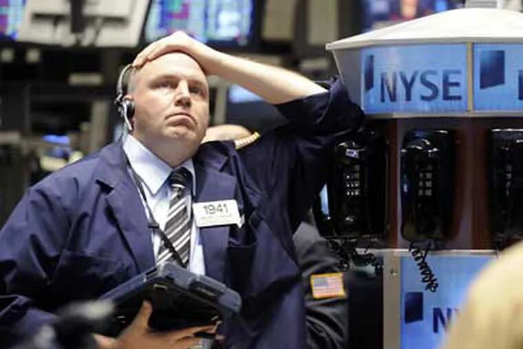 Trader Michael McCabe works on the floor of the New York Stock Exchange Thursday. Stocks have plunged again to levels not seen in more than five years as hopes fade that lawmakers will soon put together an aid package for U.S. automakers. (AP Photo/Richard Drew)