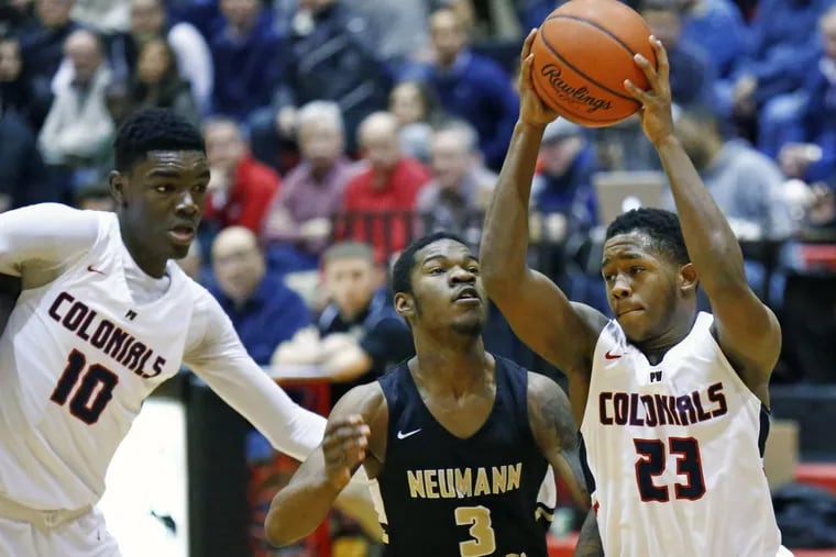 Ahmin Williams (23) of Plymouth Whitemarsh drives past Dymir Montague of Neumann-Goretti as Colonials teammate Naheem McLeod (10) sets a pick in the first quarter.