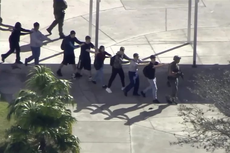 In this frame grab from video provided by WPLG-TV, students from the Marjory Stoneman Douglas High School in Parkland, Fla., evacuate the school following a shooting, Wednesday, Feb. 14, 2018.