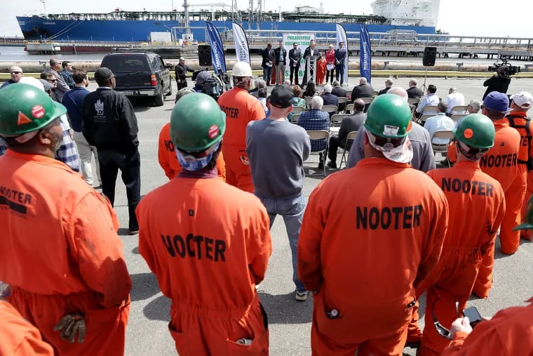 Workers gather during an announcement by Sunoco Pipline, a subsidiary of Energy Transfer Partners, of a $200 million in construction projects at the Marcus Hook Industrial Complex in Marcus Hook, PA on April 29, 2019. In the background a vessel is loaded propane and butane.