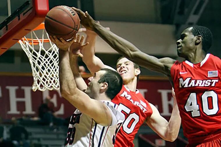 Mike Howlett goes to the basket as Marist's Chavaughn Lewis goes for the block at the Palestra. (Steven M. Falk/Staff Photographer)