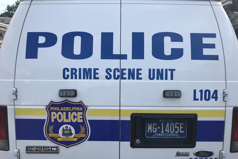 Crime scene tape and a Philadelphia Police car.