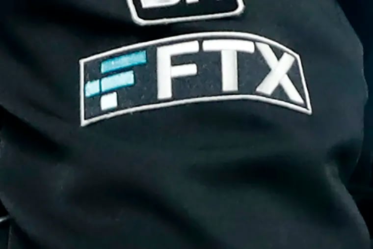 The FTX logo appears on home plate umpire Jansen Visconti's jacket at a baseball game with the Minnesota Twins in 2022 in Minneapolis.