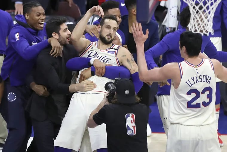 Marco Belinelli is swarmed by teammates after hitting a buzzer-beating two-pointer at the end of regulation of Game 3 on Saturday.