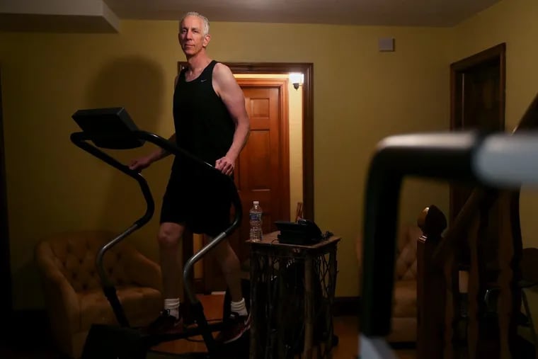Keith Morgan stands for a portrait on his elliptical machine in his Haverford home on Tuesday, March 20, 2018. TIM TAI / Staff Photographer