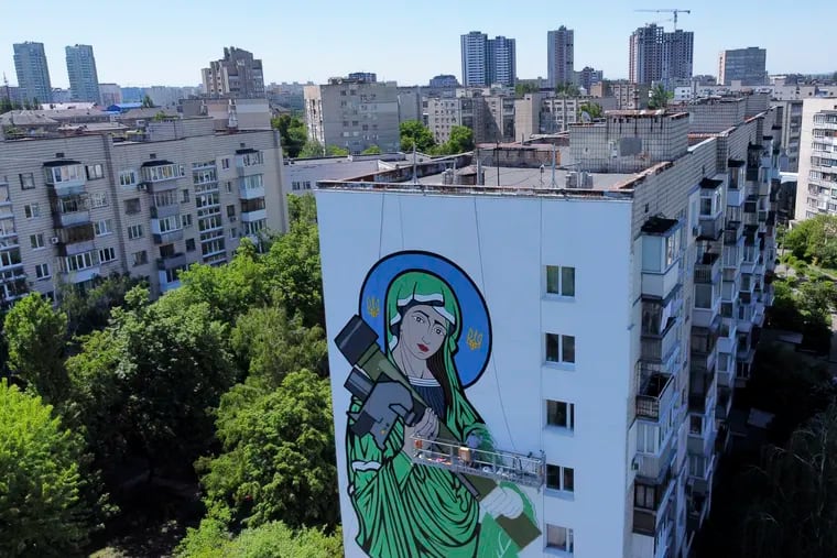 A worker painted a "Saint Javelin," a Virgin Mary holding an American-made anti-tank missile, in Kyiv, Ukraine, on Tuesday.