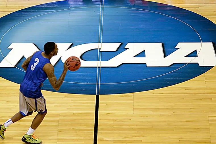 A non-roster Delaware player runs past the NCAA logo during practice. (Elaine Thompson/AP)