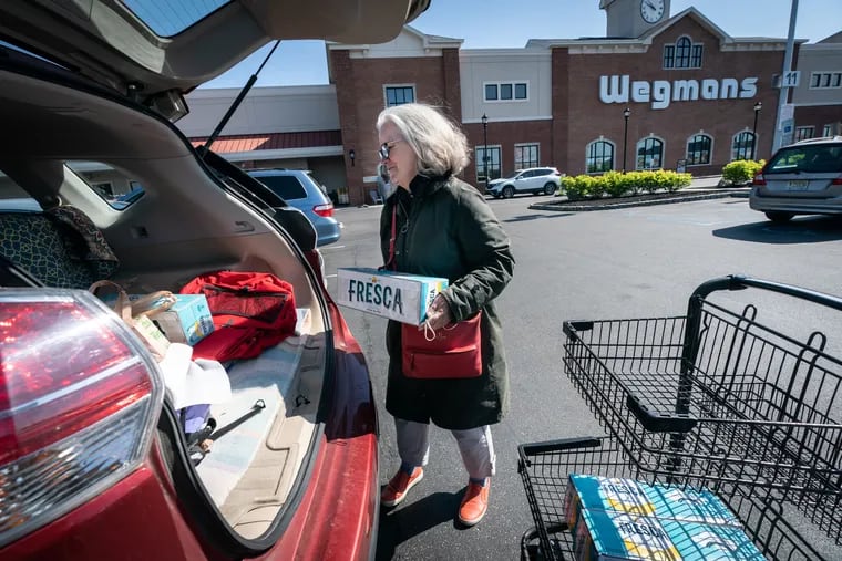 Caroline Zehren loads groceries into her car in the Wegmans supermarket parking lot in Cherry Hill. Starting May 4, Wegmans will be unable to give out either plastic or paper bags.