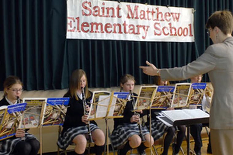 St. Matthews band director Kathleen Brown conducts eighth graders at the news conference. Musicians include (from left) clarinetists Samantha Deegan, Amy O&#0039;Neill and Jaclyn Schwartz.