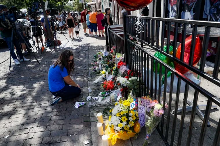 A mourner kneels at a makeshift memorial in Dayton, Ohio, on Monday.