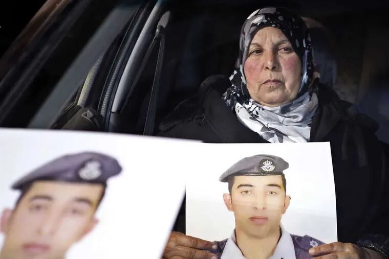 Lt. Muath al-Kaseasbeh , the Jordanian fighter pilot seized by Islamic State, is shown in a picture held by his mother outside cabinet offices in Amman, Jordan. RAAD ADAYLEH / AP
