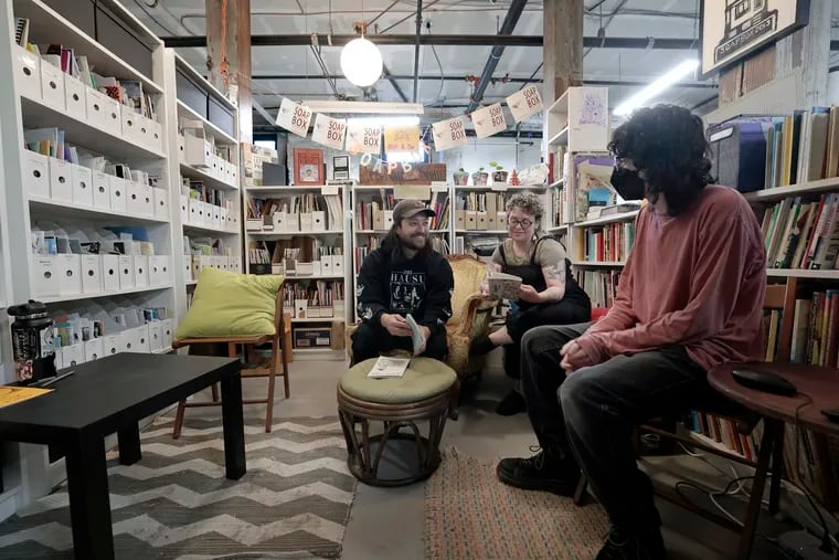 The zine library at the Soapbox, a West Philly community print shop. Studio coordinator Mateo Dresden (from left), board president Karen Lowry, and fellow Belle Handler sit among the zines.