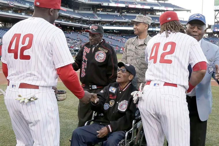 Commemorating the 69th anniversary of the day Jackie Robinson broke Major League Baseball's color barrier, Phillies Ryan Howard (left) and Emmanuel Burriss greet Tuskegee Airmen James Cotton (left), the Rev. Milton Holmes (seated), and Dr. Eugene Richardson before Friday's game against the Washington Nationals at Citizens Bank Park. All the players in every game wear Robinson's number, 42, on April 15 to honor the baseball pioneer.