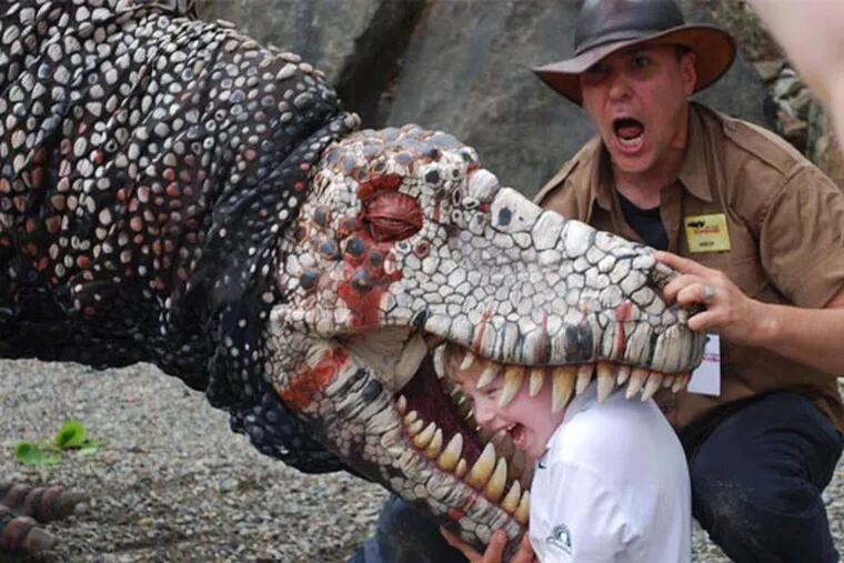 Miron Gusso helps a guest fight off a dinosaur at Field Station: Dinosaurs. The North Jersey attraction features animatronic dinosaurs that interact with visitors, as the little tyke above learned during his encounter with a robotic Dryptosaurus.