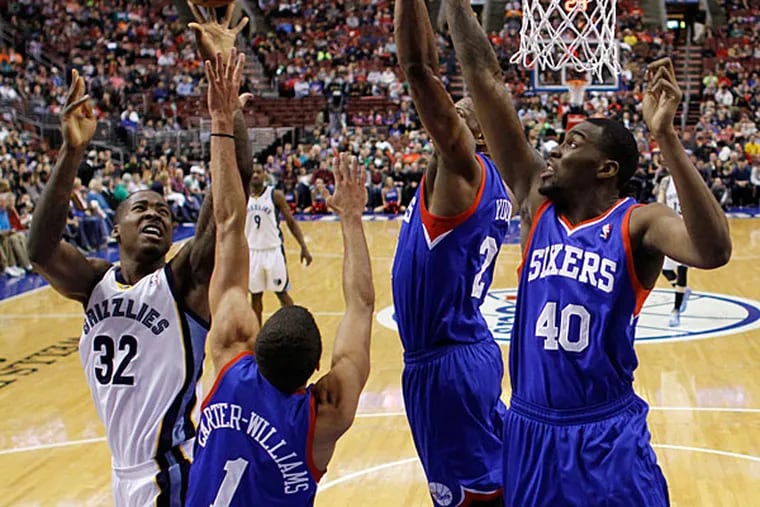 Grizzlies' Ed Davis (32) goes up for a shot against Philadelphia 76ers' Michael Carter-Williams (1), Thaddeus Young (21) and Jarvis Varnado (40) during the first half of an NBA basketball game, Saturday, March 15, 2014, in Philadelphia. (Matt Slocum/AP)