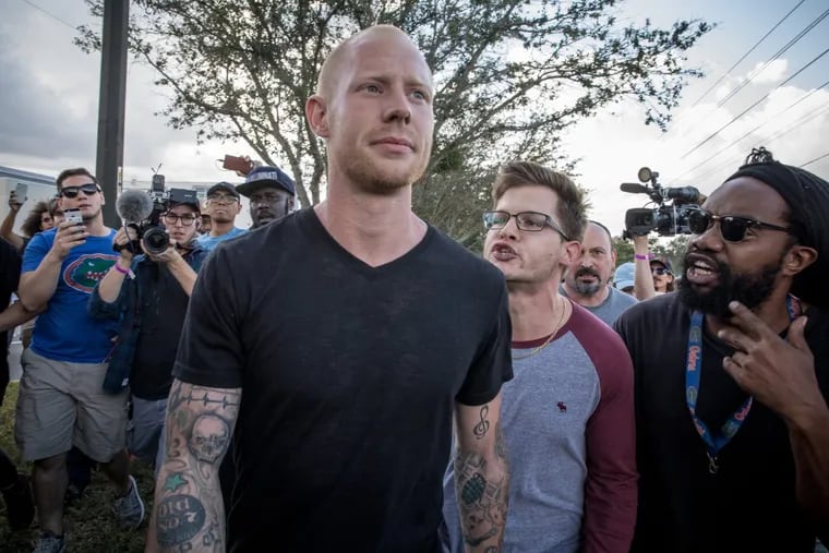 Protesters surround and shout at Tyler Eugene Tenbrink, who attended Richard Spencer’s speech, as he tries to leave the University of Florida on Thursday in Gainesville, Fla. Later Thursday, police say. he pulled a gun and fired one shot that struck a nearby building. He was arrested and faces two felony charges.
