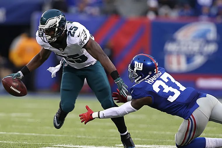 Eagles' LeSean McCoy, left, breaks a tackle attempt by the Giants'
Mike Harris, right, during the 4th quarter.  (David Maialetti/Staff Photographer)